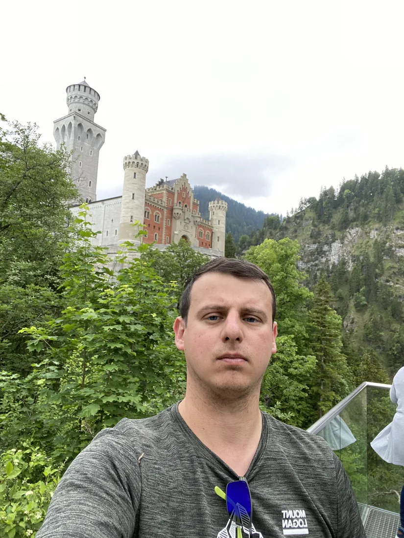 Adam na tle zamku Neuschwanstein