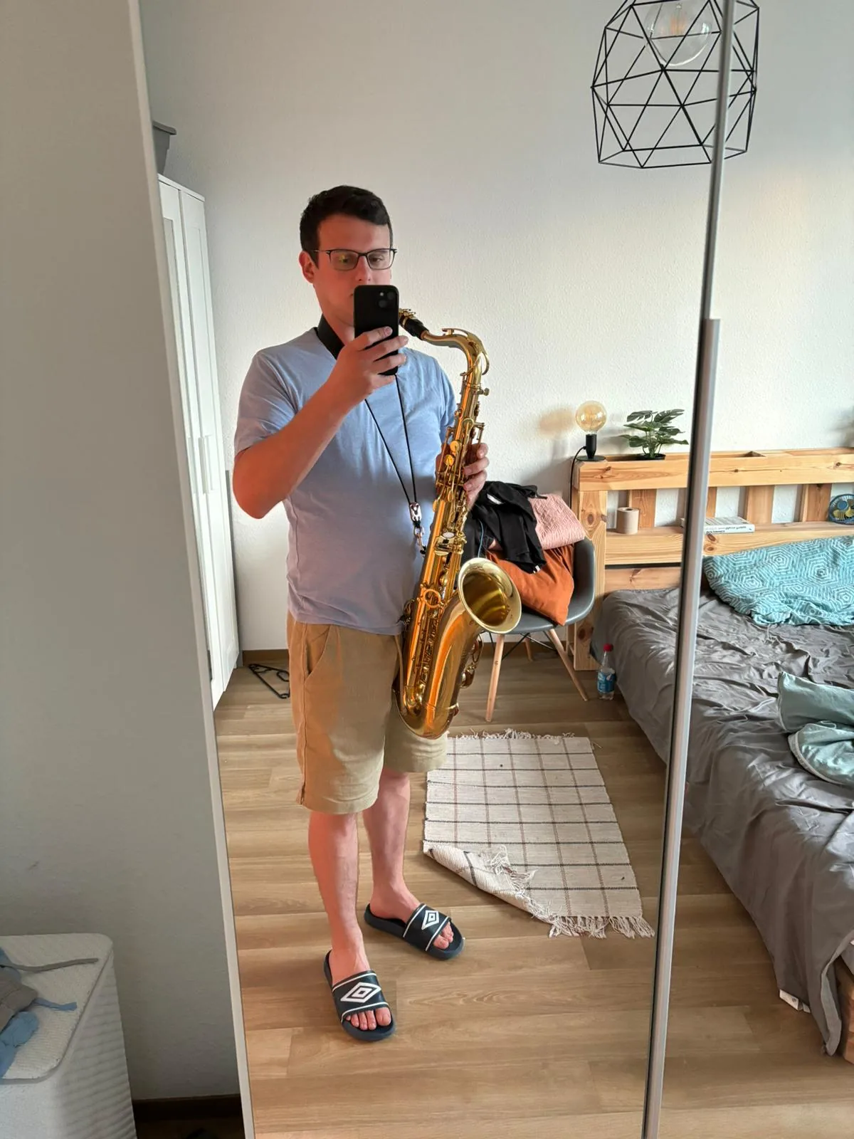Adam z saksofonem tenorowym robi sobie zdjęcie w lustrze
