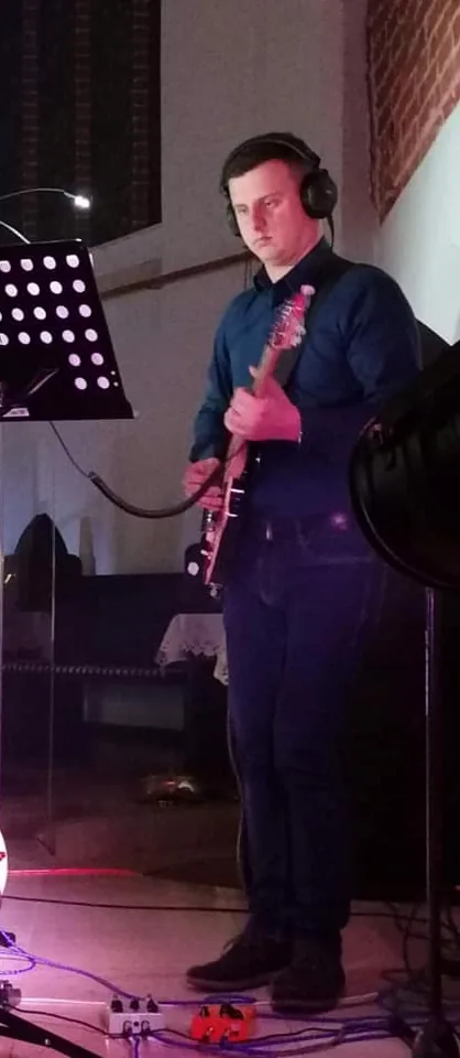 Adam z gitarą elektryczną na koncercie w kościele