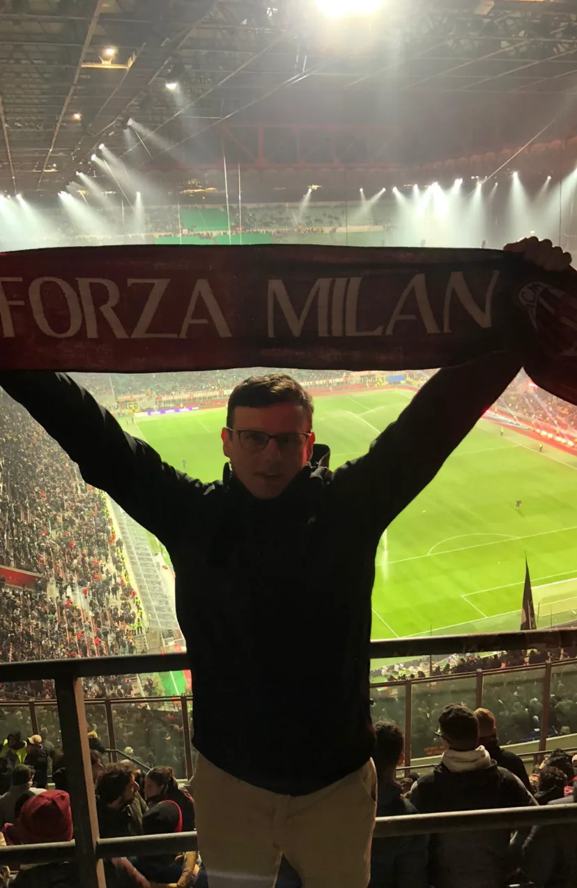 Adam na trybunie San Siro z szalikiem Forza Milan