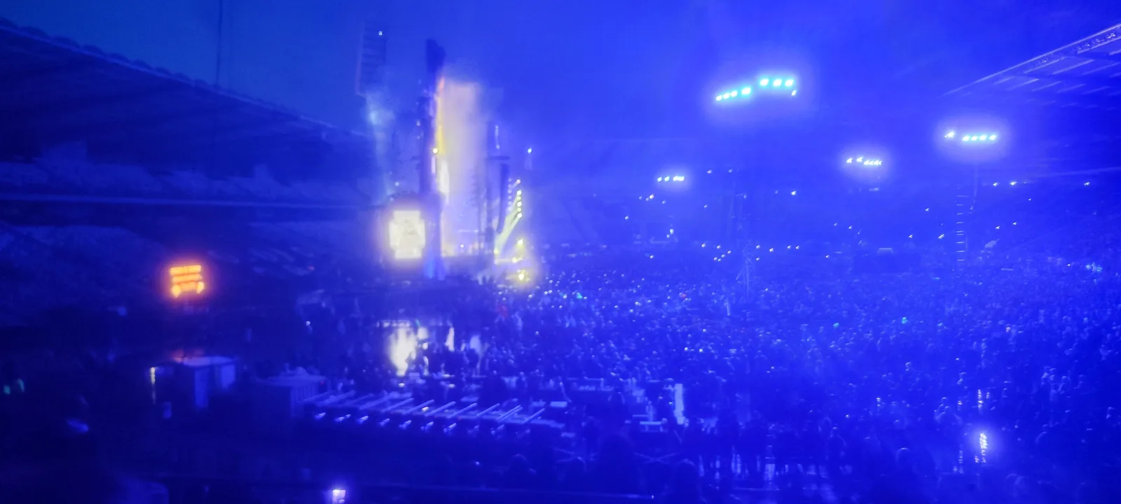 Scena Rammsteina w niebieskim świetle nad pełnym stadionem